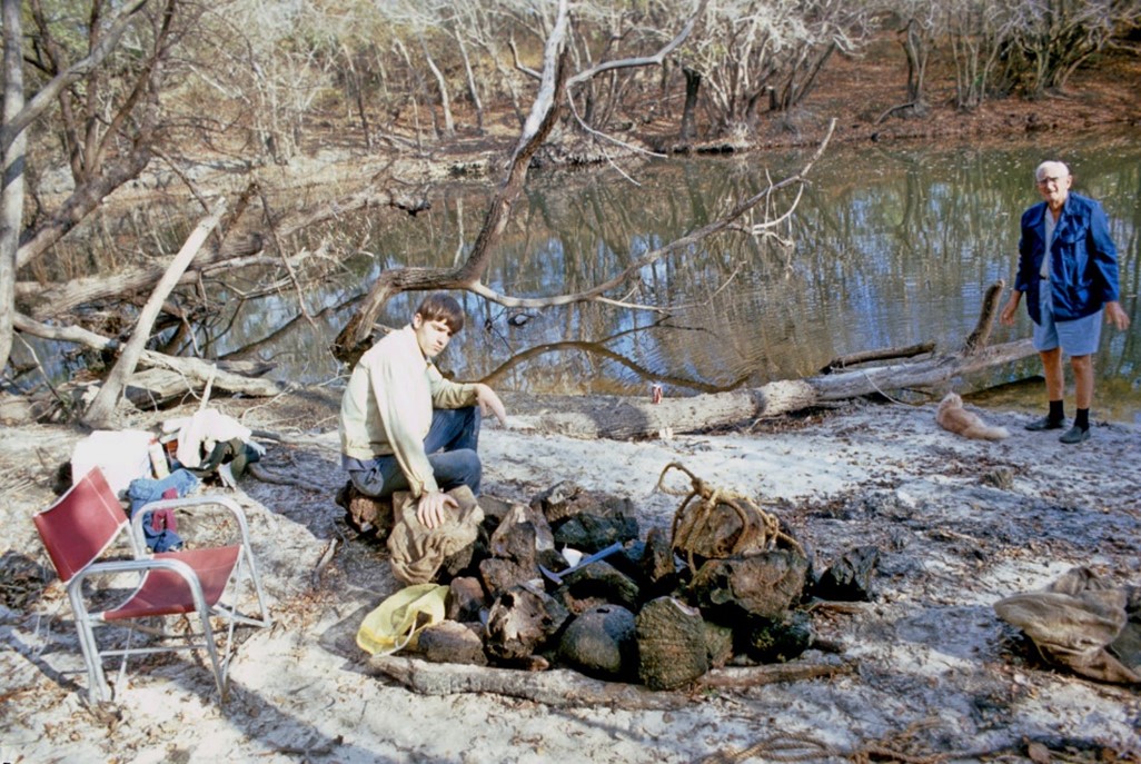 Jon with the big ones piled up at camp. Note the rope on a really large one. Grandpa and our cat in background.